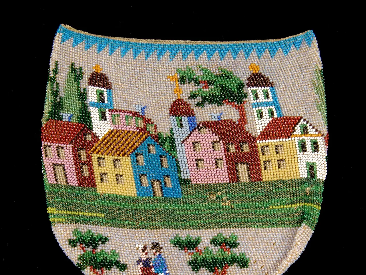 The image shows a small beaded purse with a village scene painted on it. The village is composed of...