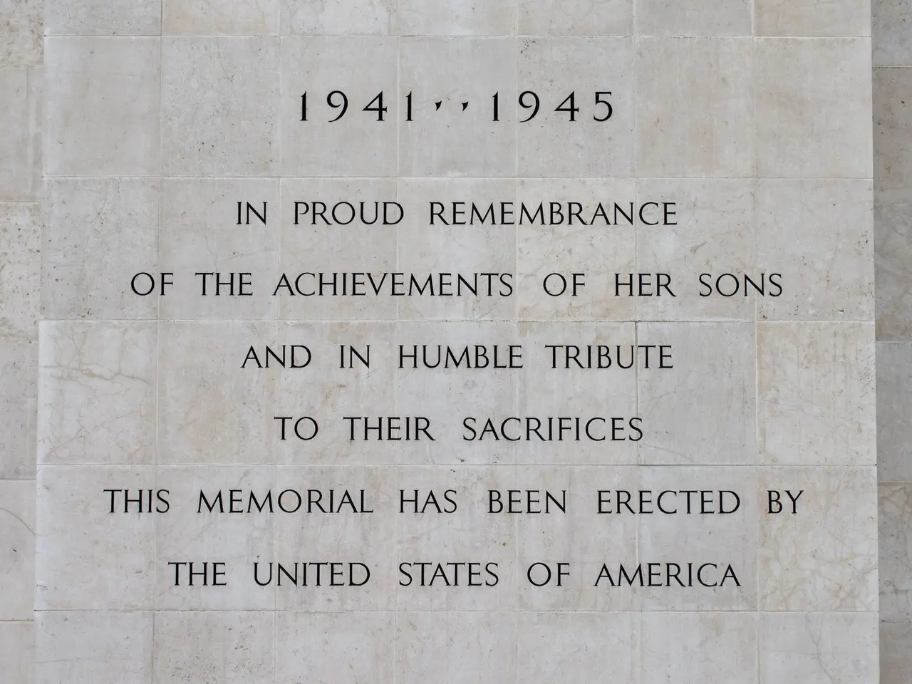 The image shows a monument with a plaque on the side of it that reads "In Proud Remembrance of the...