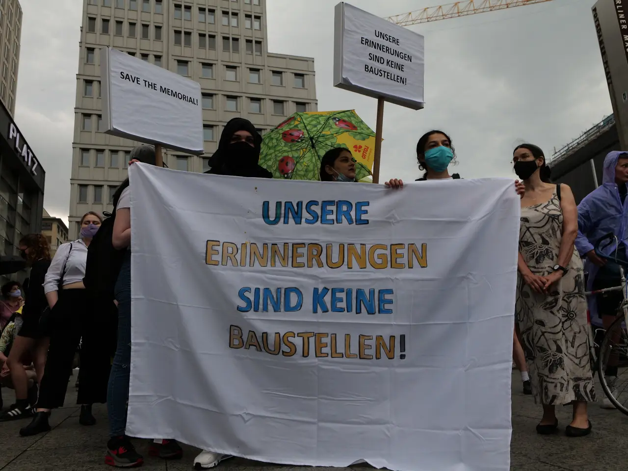 The image shows a group of people wearing masks and holding a banner that reads "Unsere...