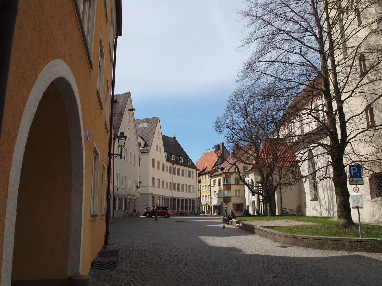 The image shows a cobblestone street in the old town of Heidelberg, Germany. On either side of the...