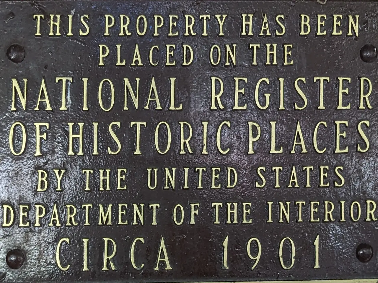 The image shows a plaque on the side of a building that reads "This property has been placed on the...