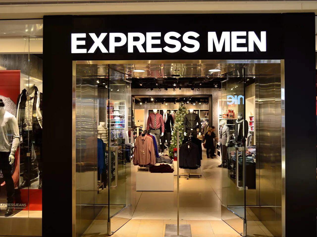 The image shows an express men store in a shopping mall, with mannequins wearing the latest...