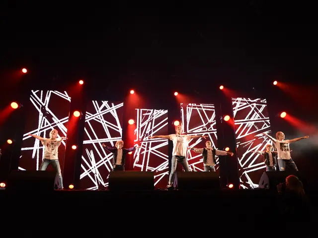 In this picture I can see some people are standing on the stage. In the background stage lights and...