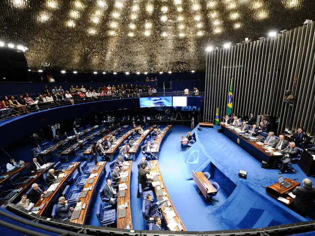 In the image it looks like some conference, there is a stage and on the stage there are a group of...