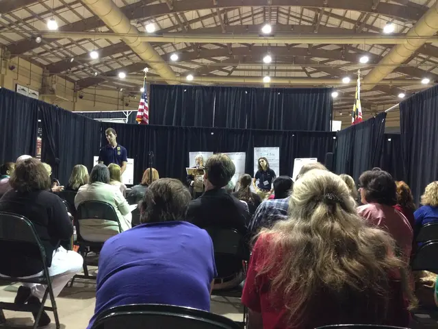 In this image we can see this people are sitting on the chairs. This person is standing at the...