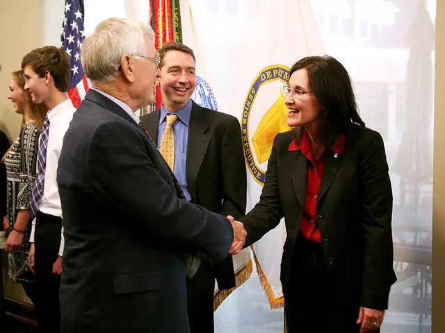 In the picture we can see a man and woman are standing and shaking hands and smiling to each other...