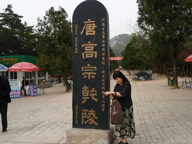 In this picture we can see the black color stone pillar with some Chinese language written on it....