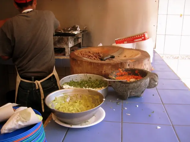 In this image there are plates, food items in the bowls, knife, a person standing, cardboard box ,...