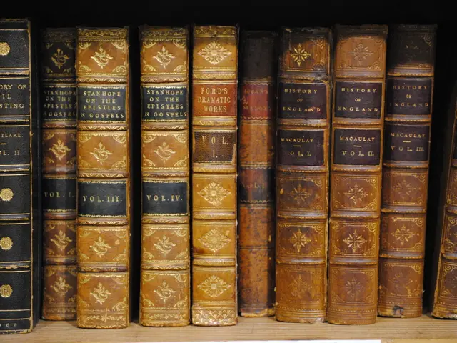 In this image I can see few books, they are in brown, cream and black color on the cream color...