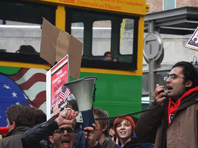 In this image there are a few people standing and holding banners in their hand and few are holding...