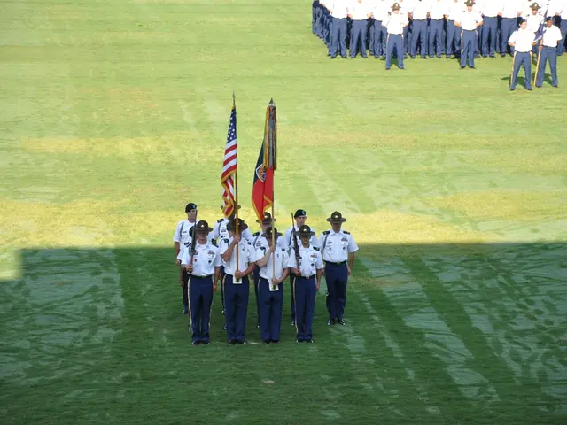 In the picture a group of boys are holding two flags with their hand by standing in an order,behind...