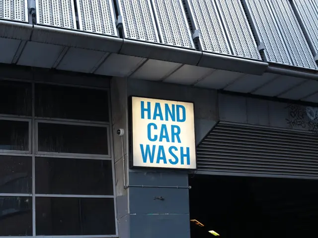 In this picture there is a building. In the center there is a board, beside that there is a camera....