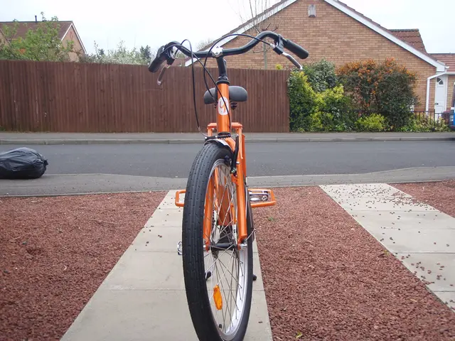 In the center of the image, we can see a bicycle on the side way and there is a bag on the road. In...