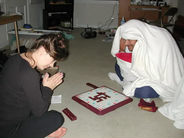 people are sitting on the floor. there is a game in front of them. the person at the left is...