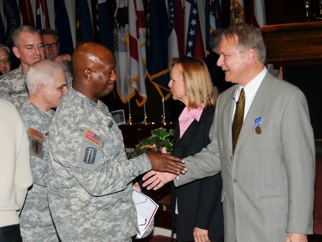 There are group of people standing. I can see two people handshaking. In the background, I think...