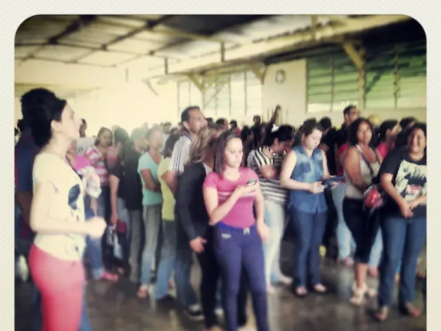 This picture describes about group of people, they are all standing, and they are in the shed, in...