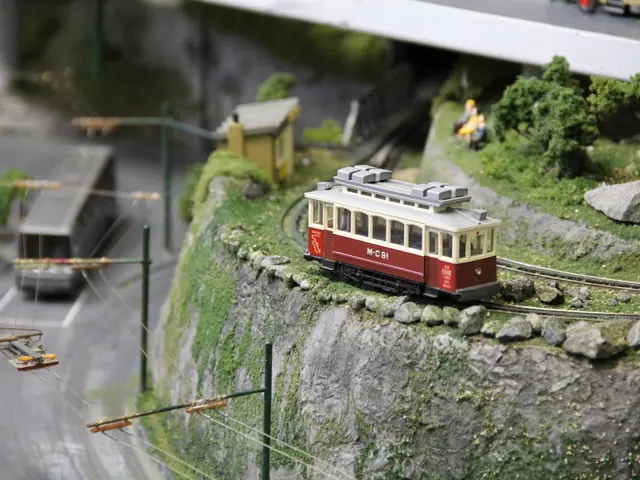 This is a model. On the right side there is a wall with rocks. On that there are railway tracks. On...