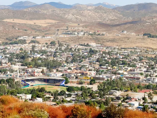 As we can see in the image there are houses, trees, current polls, hills and sky.