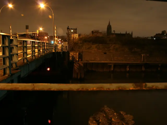 In the picture there is a bridge across the river and on the bridge there are many street lights,...