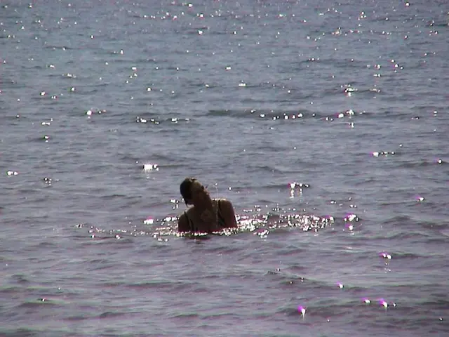 In the foreground of this picture, there is a woman in the water.