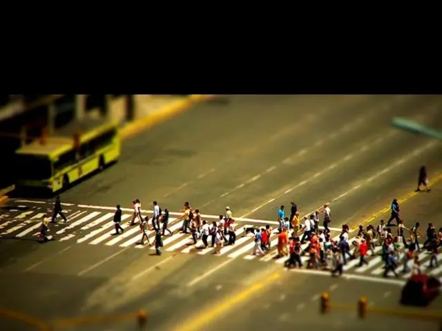 In this image there is a road and we can see people walking. There is a bus on the road and we can...