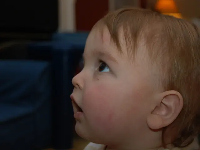 In the image in the center we can see one baby. In the background we can see wall,light,sofas and...