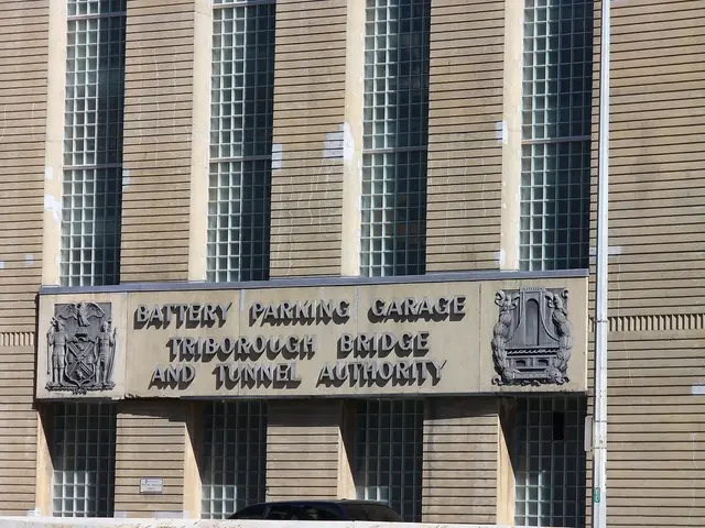 In this picture there is a building in the center of the image, on which there is a name board in...