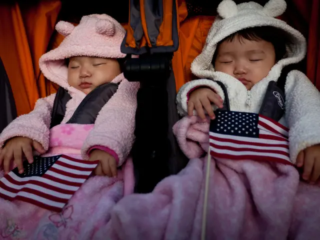In this picture, we see the two babies are sleeping in the orange and black color baby trolley. We...