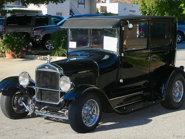 In this image there is an antique car on the road surface, behind the antique car there are...