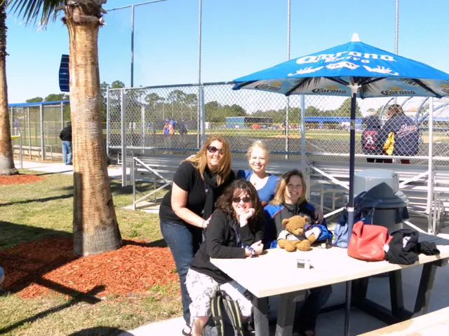 There are group of people standing and sitting in this image. There are four women in the front...