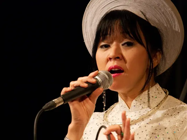 a person is singing holding a microphone in her hand. she is wearing a white dress and a white hat....