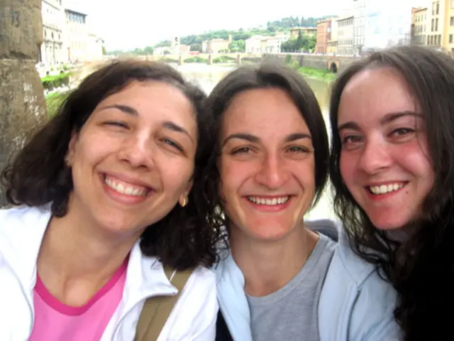 To the left side of the image there is a lady with white jacket and pink t-shirt. Beside her there...