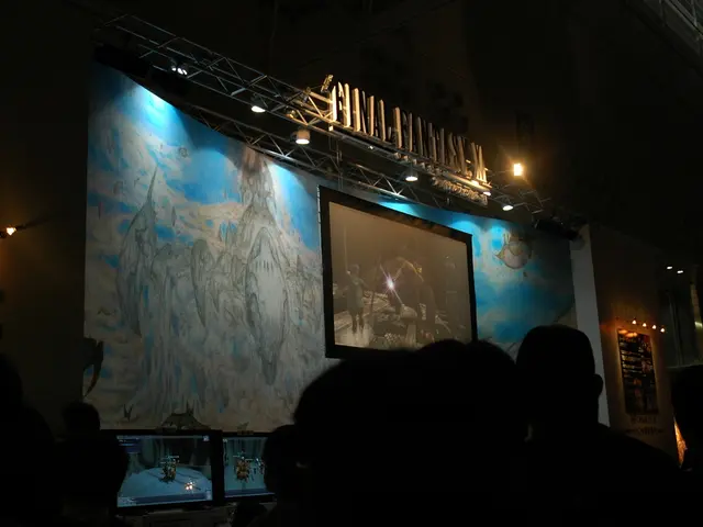 In this image there is a stage at the center where the video is displayed and group of people are...