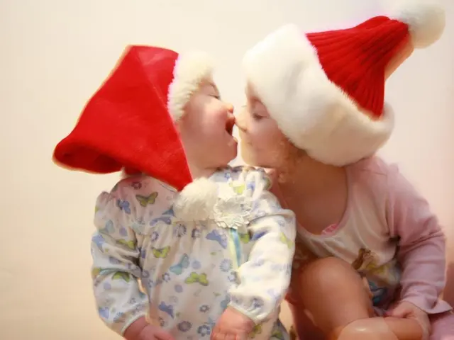 In front of the image there are two kids. Behind them there is a wall.