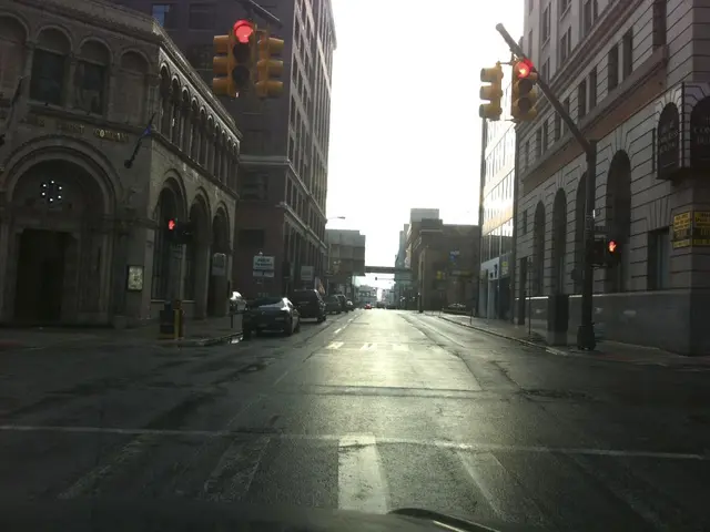 At the bottom of this image, there is a zebra crossing on a road on which there are vehicles. On...