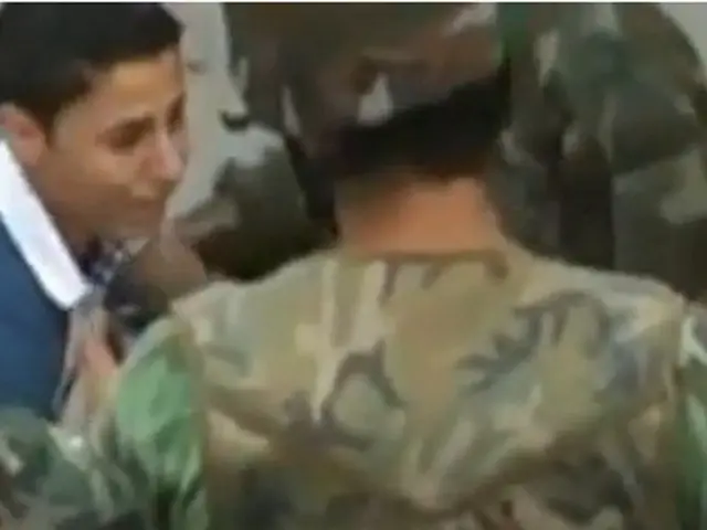 In this image there is a military officer in the middle who is holding the gun. In front of him...