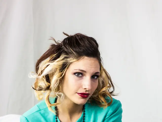 In this picture there is a woman sitting on couch and holding a bottle in her hand. In front of her...