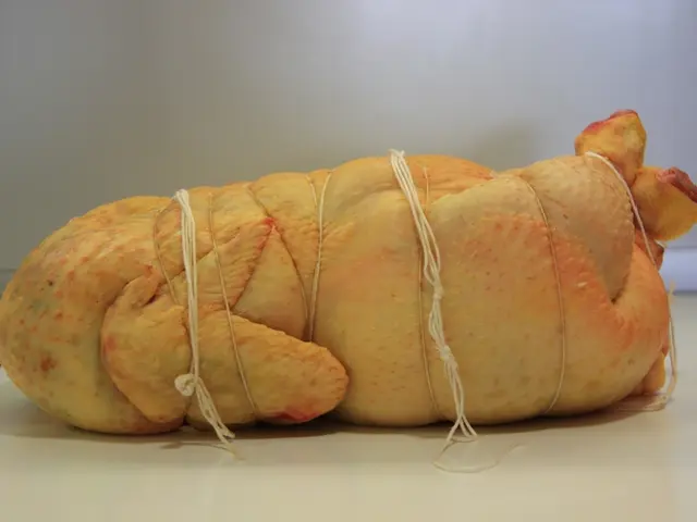 In this image I can see meat tied with the threads. There is a white background.