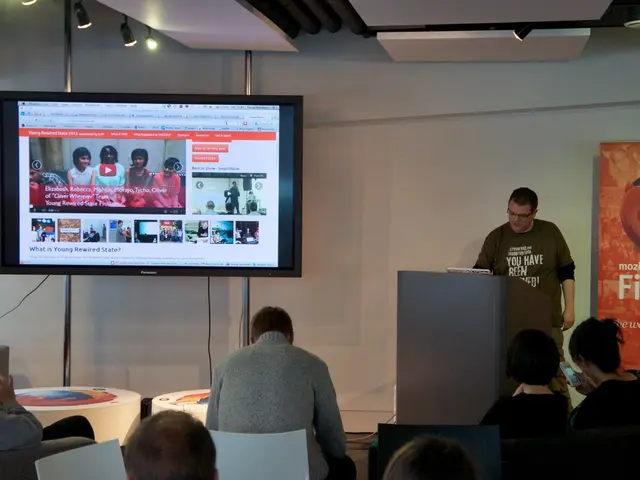 The picture is taken inside a closed room in which where people are sitting in front of the person...