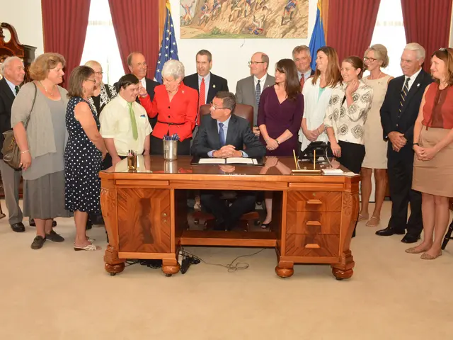 a person is seated on a brown chair wearing a suit. in front of him there is a table on which there...