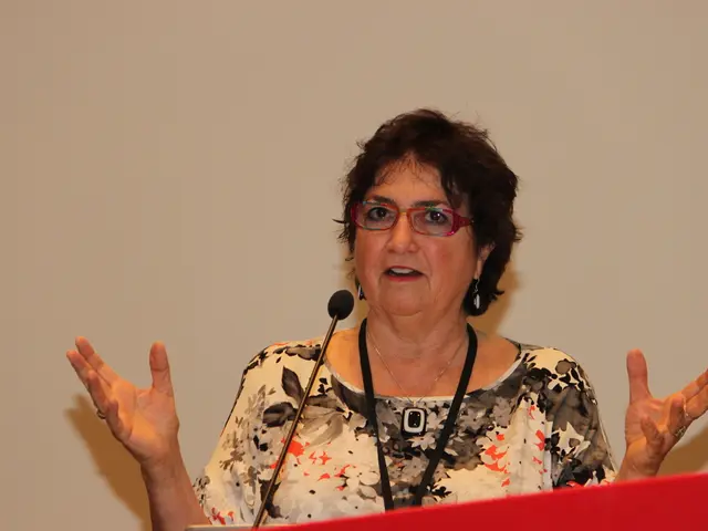 In this image we can see a woman standing at the podium and a mic is attached to it.