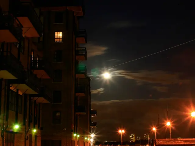 This picture tells about the and night view. In the front there is a building with many windows and...