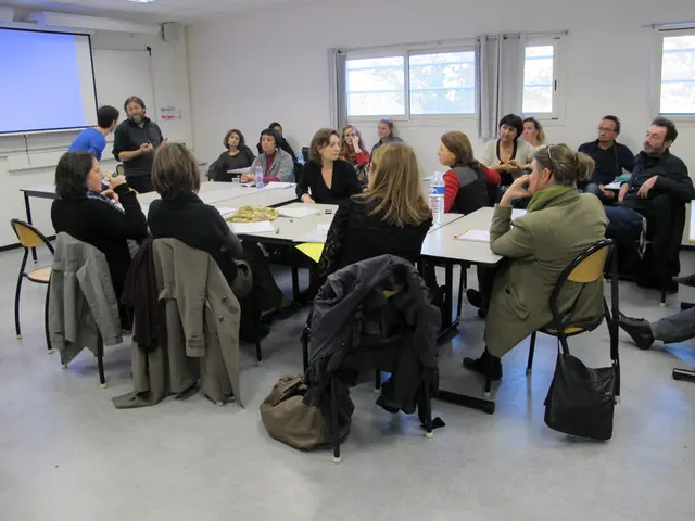 In this picture of group of people setting and discussing their and other two people standing over...