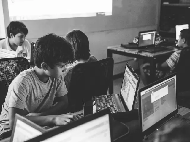 In this picture there is a table on that table there are some laptops which are in black color and...