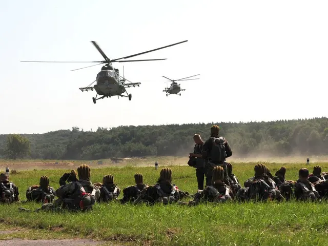 In the image we can see there are people sitting on the ground and they are carrying bags. There...