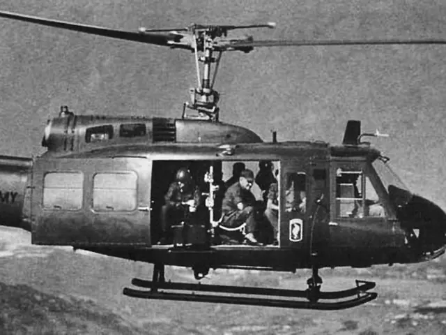 In this image I can see people sitting in a helicopter. This is a black and white image.