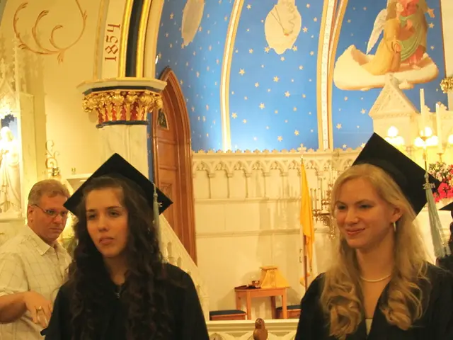 In this picture, we see two women are standing. They are holding the papers or certificates in...