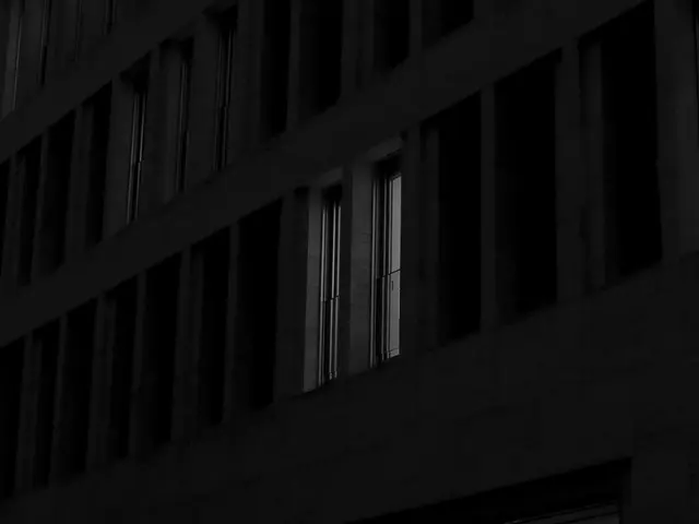 In this image we can see a building and we can also see books in racks.