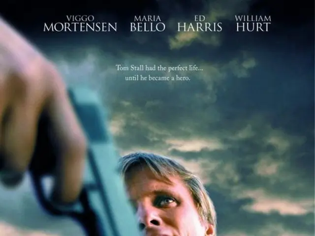 In this image we can see a man is standing, he is wearing the shirt, at back here a woman is...