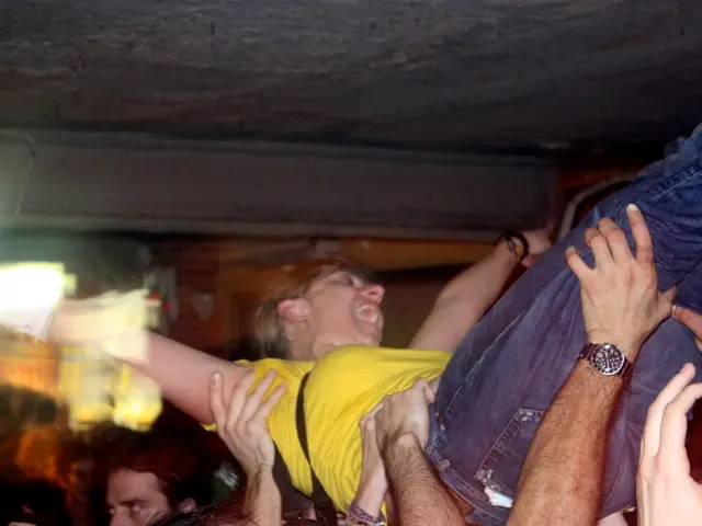 This is the women wearing yellow T-shirt and trouser. There are few people holding this woman. This...